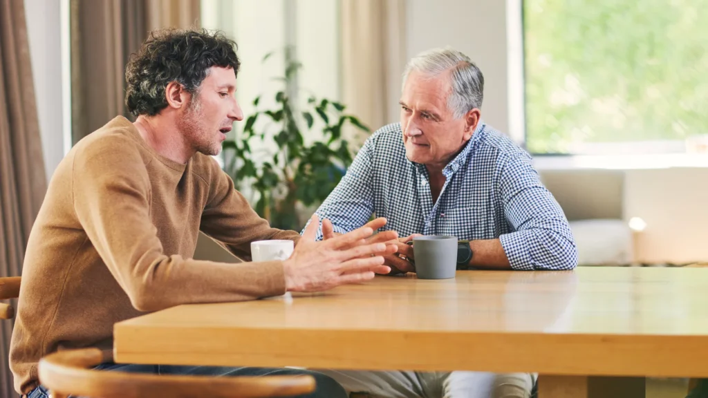 adult child talking to elderly parent about senior living