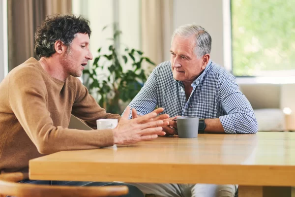adult child talking to elderly parent about senior living